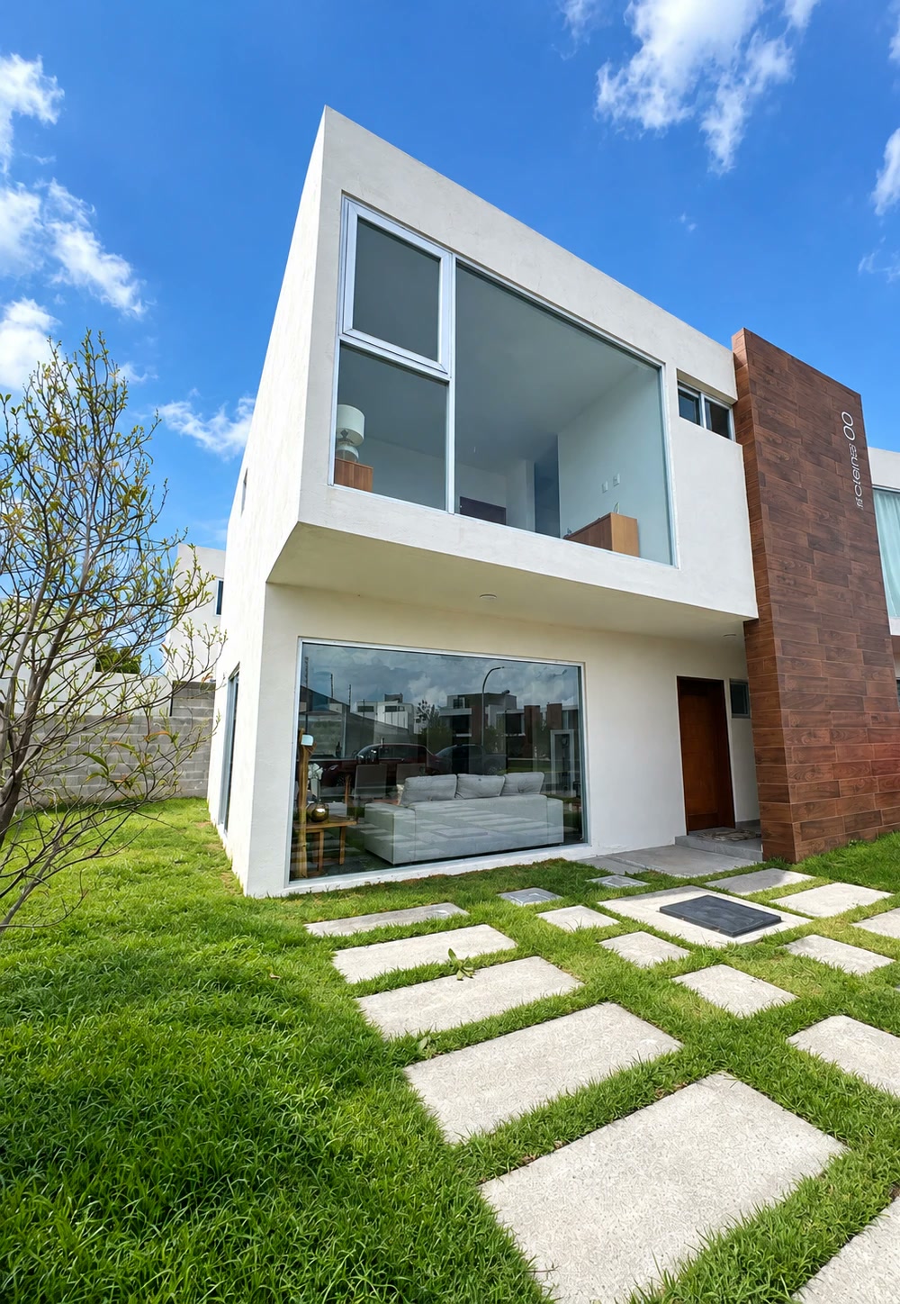 Fachada de la Casa 1 con su jardín propio y acceso empedrado