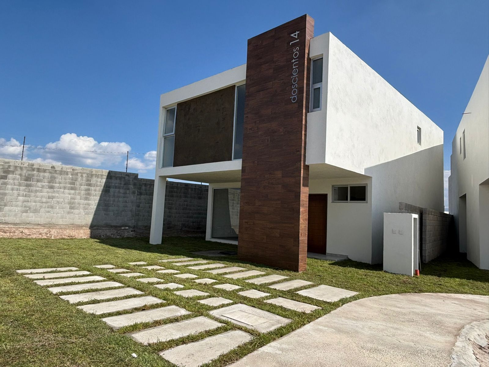Fachada de la Casa 3 con su jardín amplio